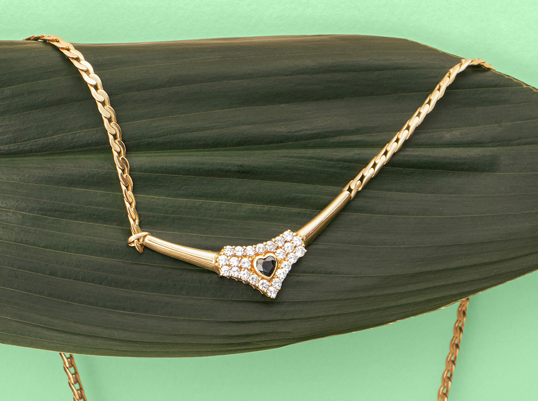 Colar de ouro com diamantes sobre folha tropical, símbolo do luxo sustentável Orit